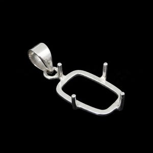 Puede incluir: Un colgante plateado con un bisel rectangular y cuatro garras. El colgante tiene un lazo para una cadena y está sobre un fondo negro. Este componente de joyería está diseñado para la creación de collares.