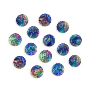 May include: Twelve round iridescent abalone shell cabochons in shades of blue, green, and purple. The cabochons are approximately 1 inch in diameter.