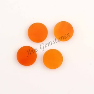 May include: Four round, orange cabochon gemstones on a white background. Ave Gemstones is written in black text on the image.