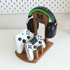 May include: A wooden stand with a green and black headset, two video game controllers, and a personalized nameplate that reads "M Michael Madlines".