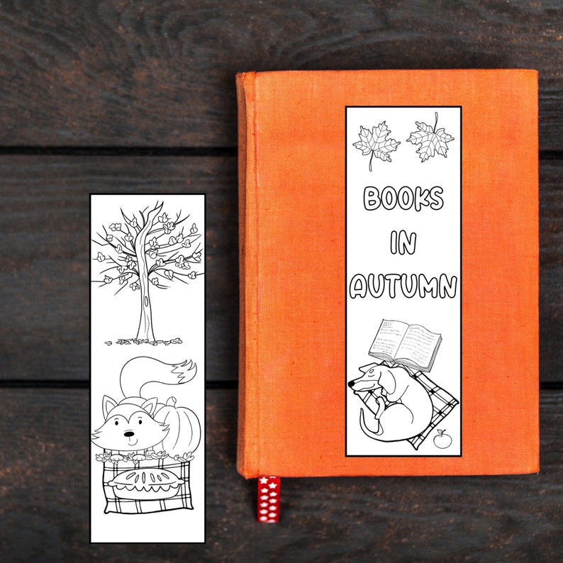 May include: Black and white printable bookmark featuring a fox with a pumpkin, a tree with leaves, and a dog with a book. The bookmark has the text "BOOKS IN AUTUMN" and two fall leaves.