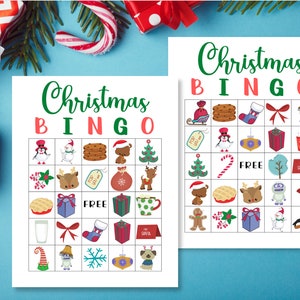 May include: Two printable Christmas Bingo cards with a variety of festive images, including a snowman, a reindeer, a stocking, a gift, a candy cane, a Christmas tree, and a gingerbread man. The cards say "Christmas Bingo" at the top.
