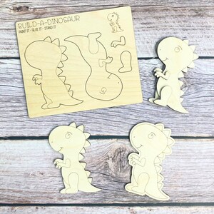 May include: Build-A-Dinosaur craft kit with five wooden pieces to paint, glue, and assemble. The kit includes a dinosaur body, head, tail, and two legs.