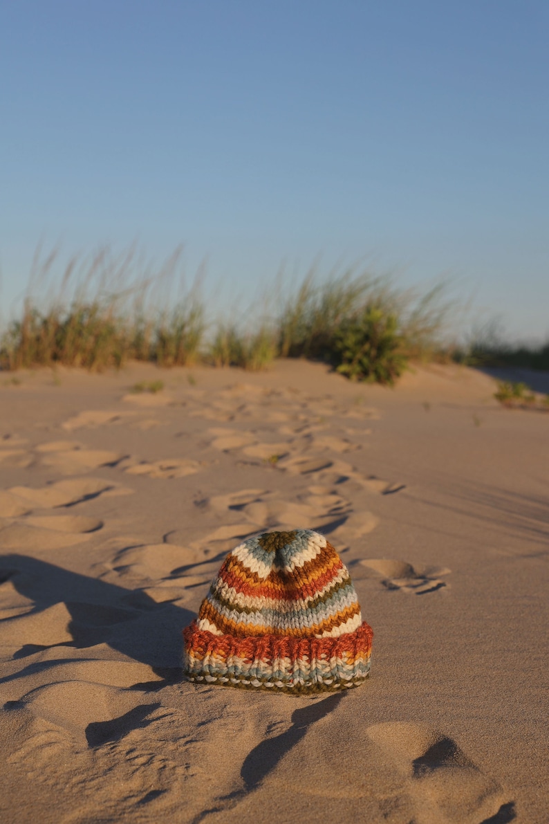 May include: A set of three ceramic vases in varying heights. The vases have a matte finish in shades of cream, beige, and brown. The tallest vase is approximately 10 inches high.