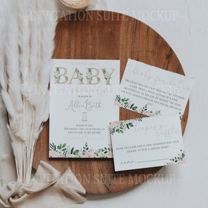 May include: A baby shower invitation suite mockup. The main invitation card features floral accents, alongside a "books for baby" card and a "diaper raffle" card. The word "BABY" is decorated with floral elements.