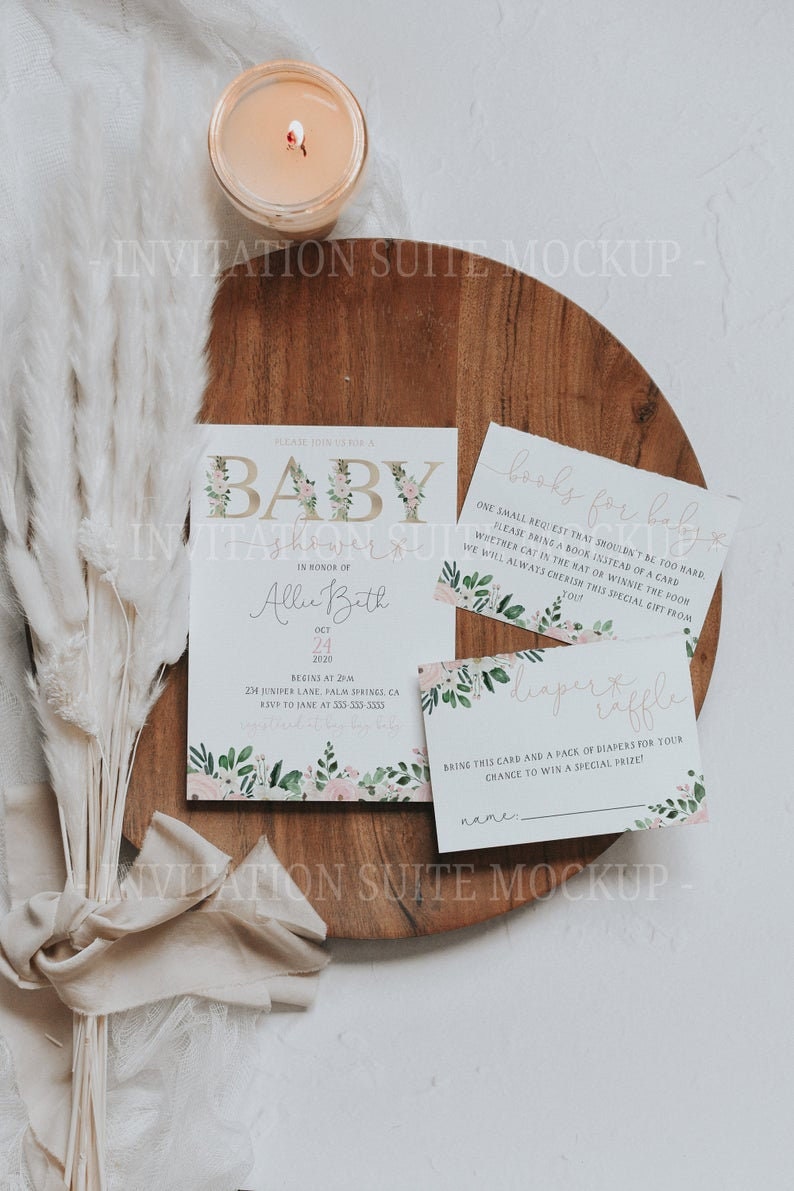 May include: A baby shower invitation suite mockup. The main invitation card features floral accents, alongside a "books for baby" card and a "diaper raffle" card. The word "BABY" is decorated with floral elements.