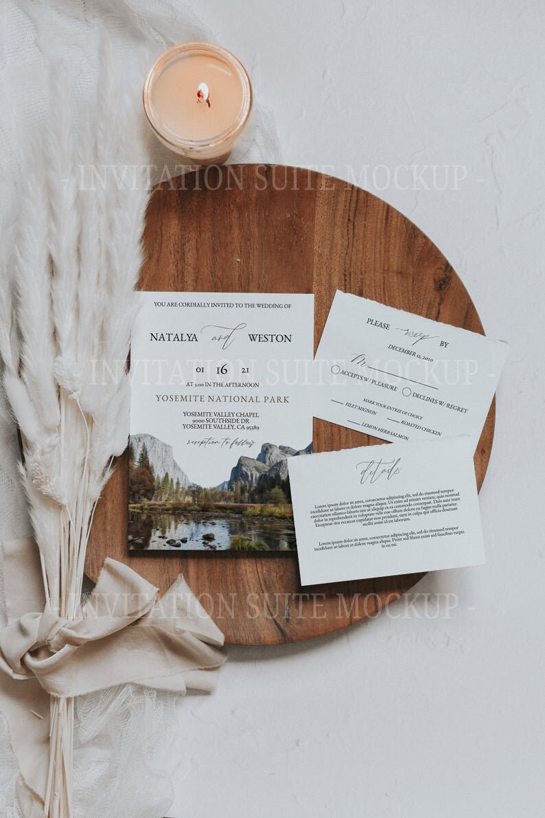May include: A wedding invitation suite mockup, including a wooden board, a lit candle, and invitation cards. The main card shows the names Natalya and Weston, the date, and a landscape. Other cards feature RSVP details and further information.