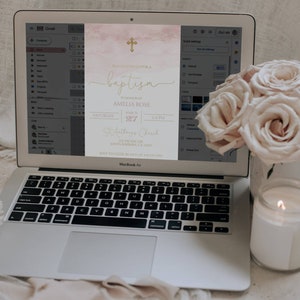 May include: A digital invitation for a baptism with a watercolor background in shades of pink and gold. The invitation features a gold cross, the text "Please join us for a baptism", the name "Amelia Rose", the date "March 27", the time "2-6 PM", the location "St. Anthony's Church", and the address "231 Pacific Dr, Santa Barbara, CA 1245".