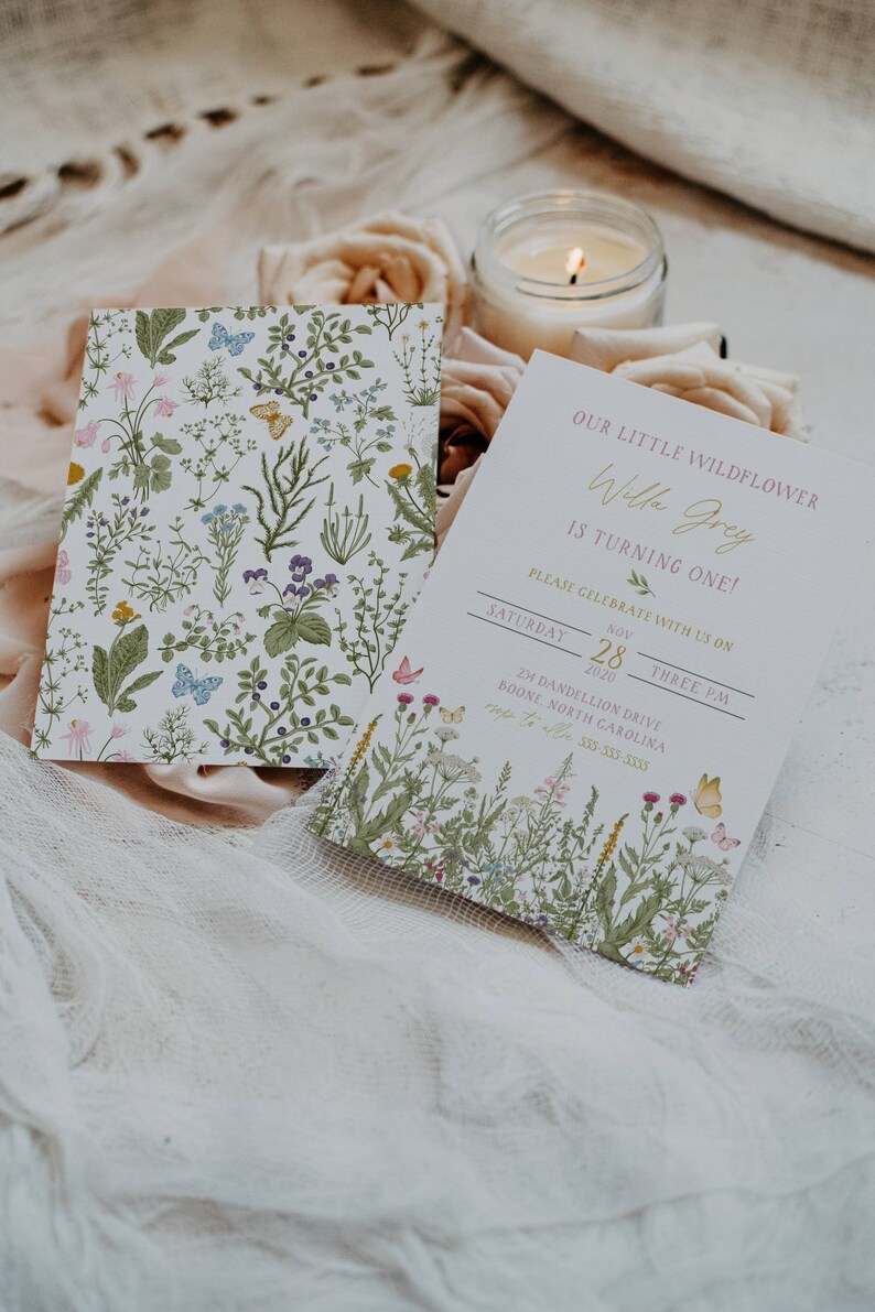 May include: A floral-themed invitation for a first birthday party. The invitation features a watercolor illustration of wildflowers and butterflies. The text on the invitation reads "Our little wildflower Willa Grey is turning one! Please celebrate with us on Saturday, November 28, 2020, at three PM. 24 Dandelion Drive, Boone, North Carolina."