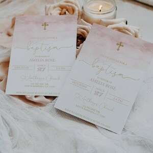 May include: Two pink and white watercolor baptism invitations with gold lettering. The invitations announce a baptism for Amelia Rose on March 27th at 2:00 PM at St. Anthony's Church. The invitations include the church address and an RSVP request.