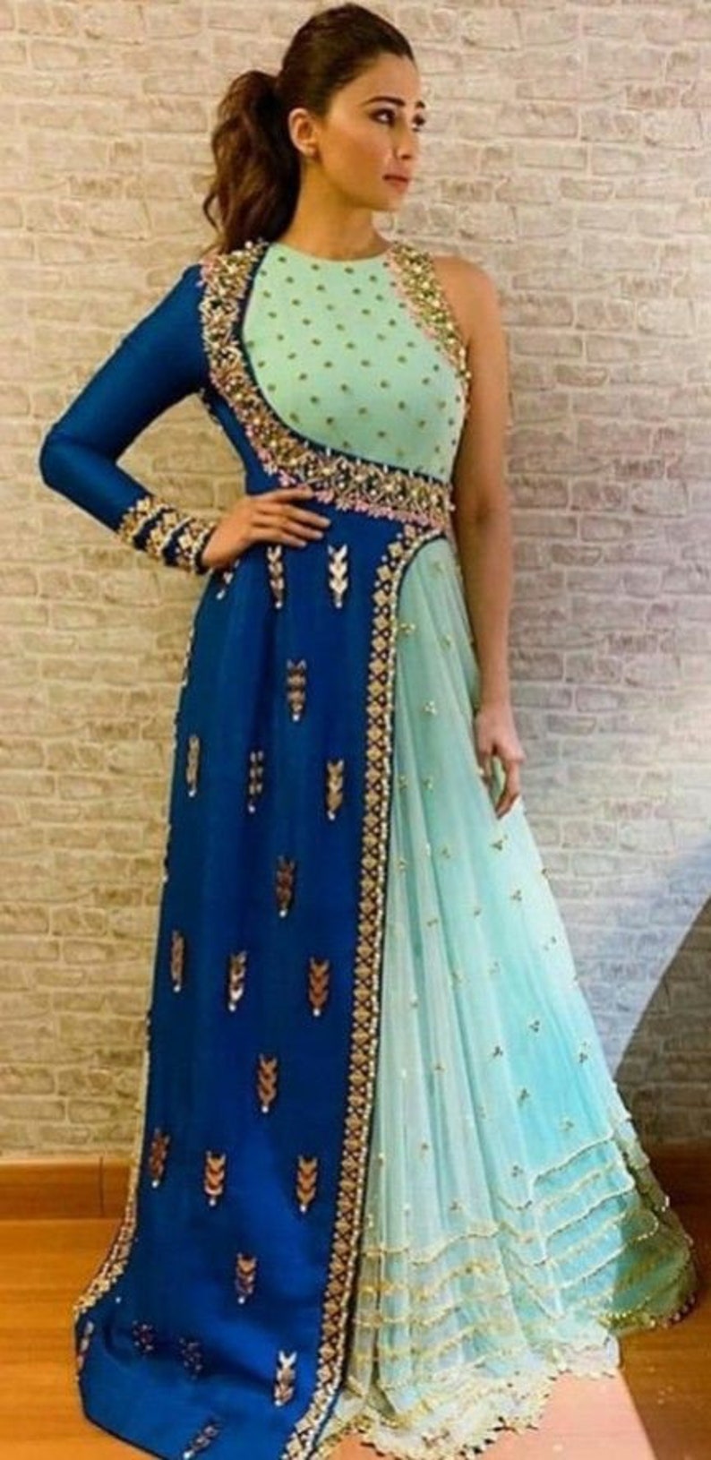 May include: A two-tone formal gown in shades of blue and mint green. The dress features intricate gold embroidery along the neckline, waist, and hem. The bodice is mint green with gold embellishments, and the skirt is a flowing design.