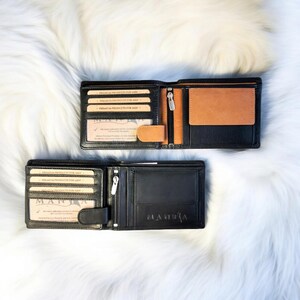 May include: Two black leather wallets with a brown leather interior. The wallets have multiple card slots and a money clip. The wallets are open to show the interior. The text "PREMIUM PRODUCTS FOR MEN" is printed on the inside of the wallets.