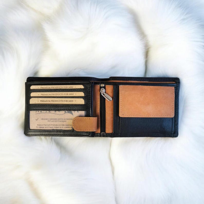 May include: Black leather wallet with a brown leather interior. The wallet has multiple card slots and a zippered compartment. The wallet is open and the interior is visible.