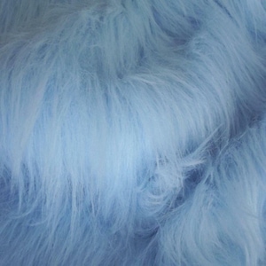May include: A close-up of a soft, light blue faux fur fabric. The fur is fluffy and has a subtle sheen.