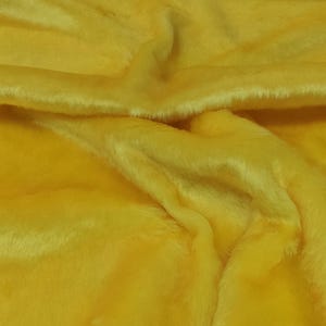 Puede incluir: Primer plano de una tela de piel sintética de color amarillo brillante. La tela es suave y esponjosa, con un brillo sutil.