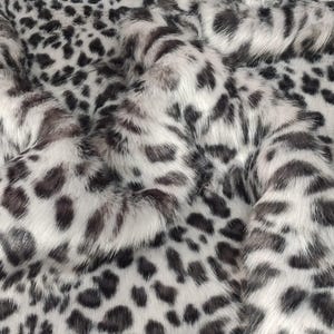 May include: White and black faux fur fabric with a leopard print pattern.