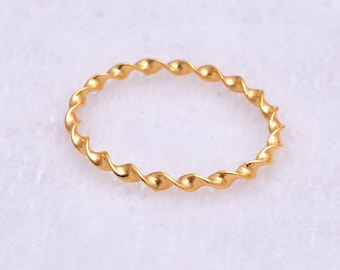 May include: A gold-colored twisted band ring.