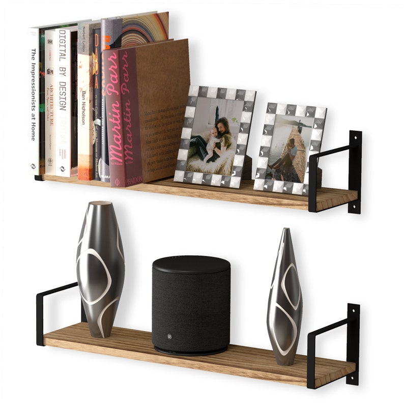 Two rustic shelves burnt holding a variety of books, family frames and stylish vases. These shelves are made of wood and supported by black metal brackets that attach to the wall, giving them a modern and somewhat industrial look.