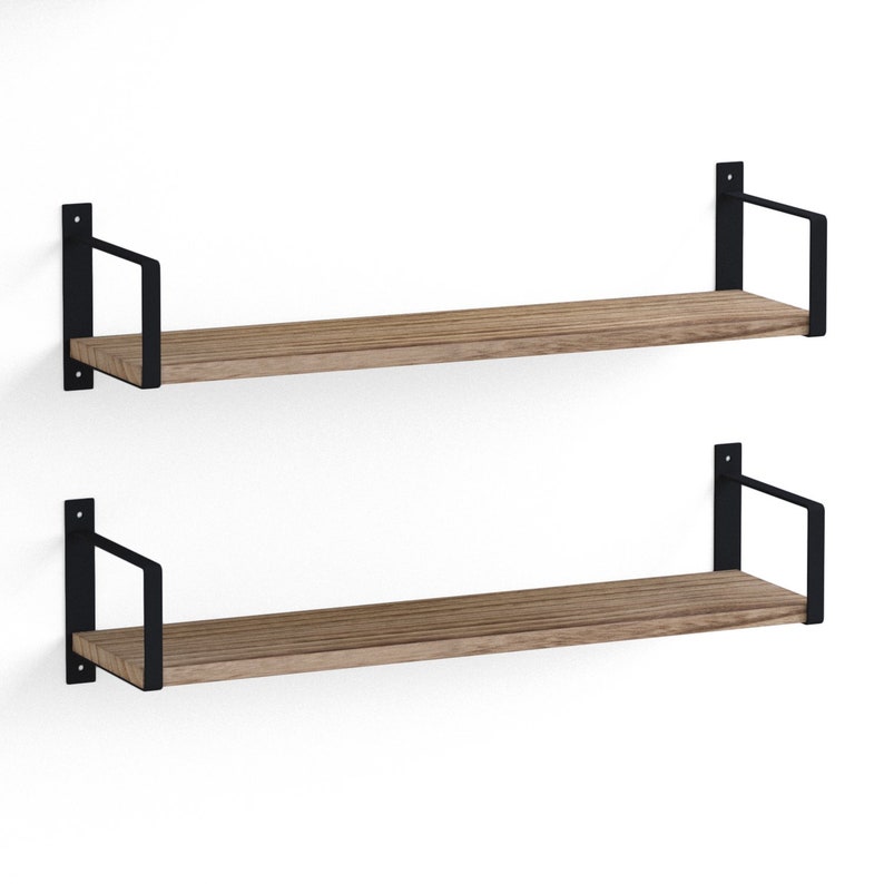 Two empty wooden shelves burnt holding a variety of books. These shelves are made of wood and supported by black metal brackets that attach to the wall, giving them a modern and somewhat industrial look.