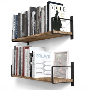 Two shelves for wall decor  holding a variety of books. These shelves are made of wood and supported by black metal brackets that attach to the wall, giving them a modern and somewhat industrial look.