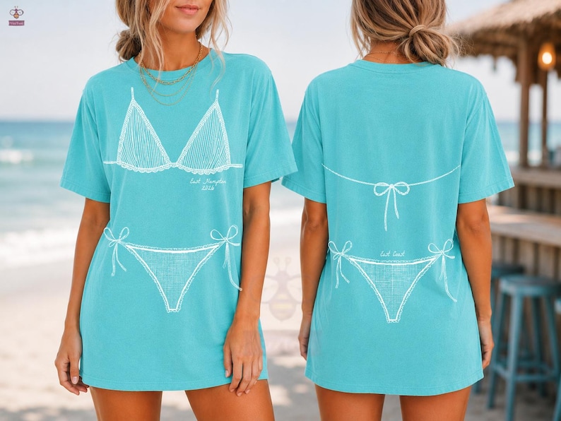 May include: A turquoise short-sleeve t-shirt featuring a white line-art graphic of a bikini. The front displays the bikini top and bottom with the text 'East Hampton 2024'. The back shows the bikini bottom and the tie-back detail of the top.