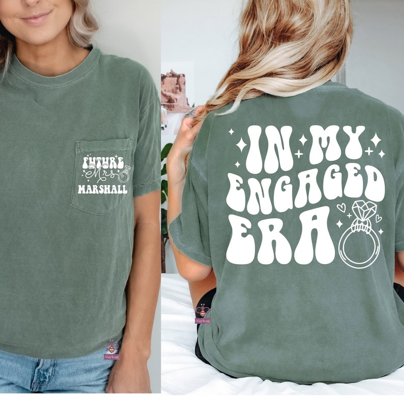 May include: A green t-shirt with a pocket on the front and a graphic on the back. The pocket has the text "Future Mrs. Marshall" with a ring design. The back graphic says "In My Engaged Era" with a ring design.