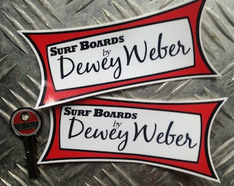 Könnte beinhalten: Zwei rote und weiße Surfbrett-Aufkleber mit schwarzem Text, der "Surf Boards by Dewey Weber" lautet.