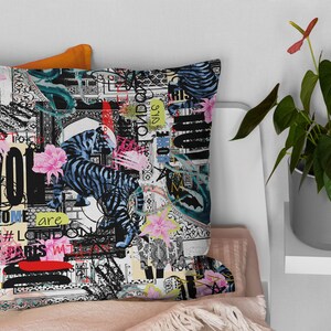 May include: A black and white cushion with a colourful abstract design featuring tigers, flowers, and text. The text includes "Some are", "#London", "Paris", and "Yo!"