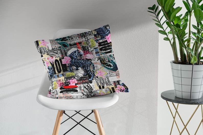 May include: A white throw pillow with a colourful, abstract print featuring a tiger, flowers, and text. The text includes the words "Love", "Paris", and "London".