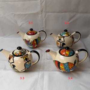 May include: Four ceramic teapots with black handles and lids. The teapots have a cream-coloured base and are decorated with colourful abstract designs. The spouts are red and the lids are black. The teapots are numbered 3.1, 3.2, 3.3, and 3.4.