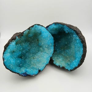 May include: Two halves of a geode with a blue crystal interior and a dark brown exterior.