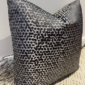 May include: A black and silver pillow with a leopard print pattern.