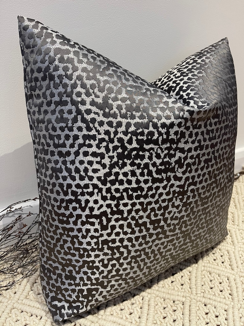 May include: A black and silver pillow with a leopard print pattern.