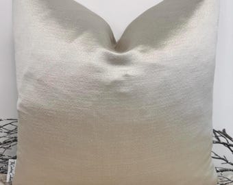 May include: A soft, light beige pillow cover with a subtle ombre effect, transitioning from a lighter shade of beige to a darker shade. The pillow cover is made of a smooth, silky fabric.