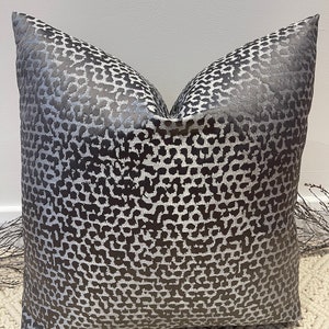 May include: A gray and silver pillow with a leopard print pattern.