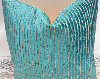 May include: Teal and gold striped cushion with a yellow border. The cushion is made of a soft, velvety fabric.