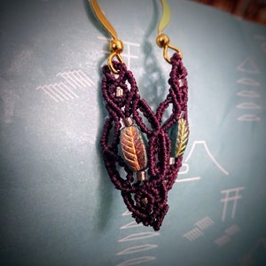 May include: Burgundy macrame earrings with gold hoops and green and gold leaf accents.