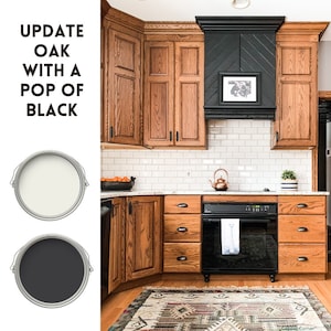 May include: A kitchen with oak cabinets painted black. The cabinets have black hardware. The kitchen also has white subway tile backsplash and a black range hood. The text "UPDATE OAK WITH A POP OF BLACK" is in the image.