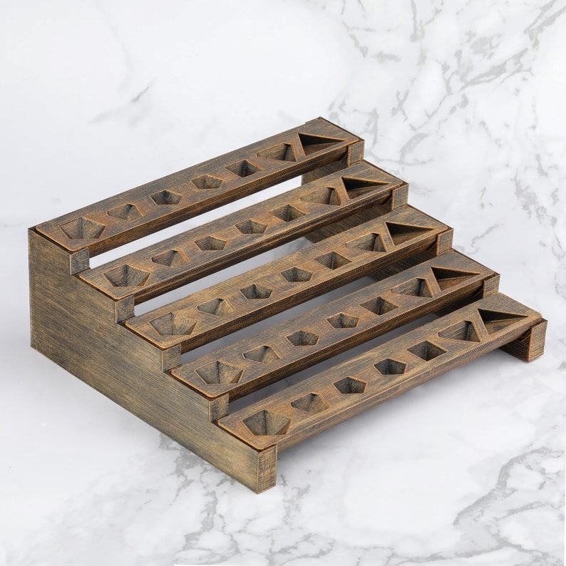 Peut inclure: Pr&eacute;sentoir en bois &agrave; quatre niveaux, fini brun fonc&eacute;. Chaque niveau pr&eacute;sente des d&eacute;coupes g&eacute;om&eacute;triques, notamment des pentagones et des triangles. La structure est en gradins, chaque niveau &eacute;tant plus petit que le pr&eacute;c&eacute;dent.