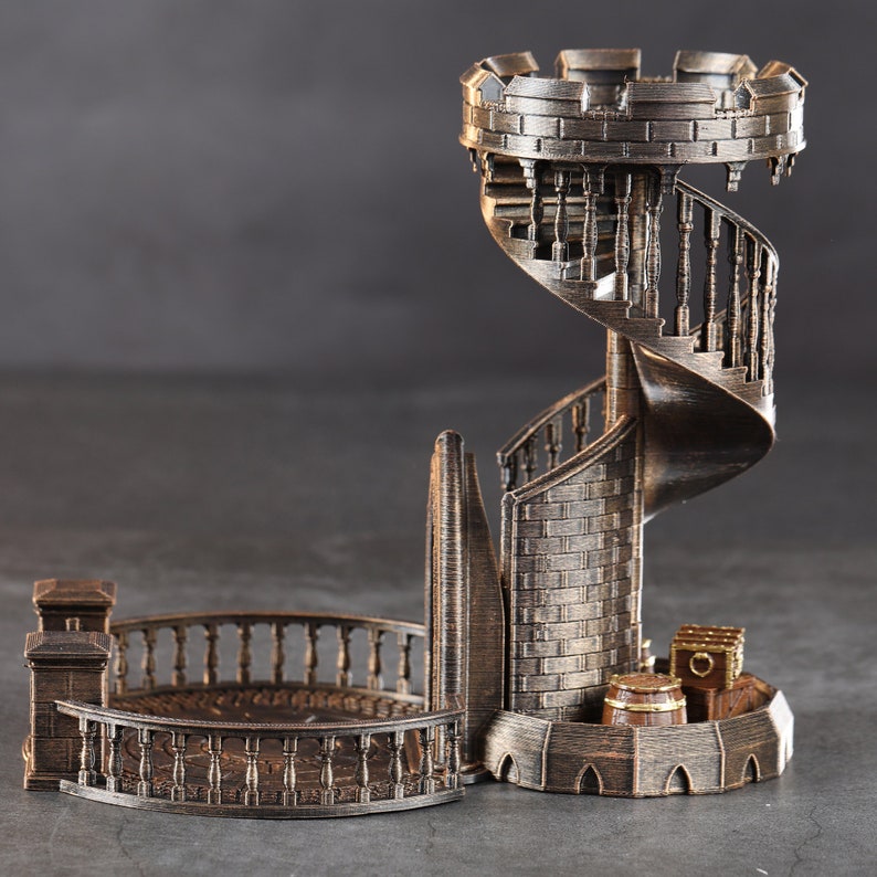 May include: A 3D printed, bronze-colored tower with a spiral staircase and a small balcony. The tower is made of a brick-like material and has a detailed design.
