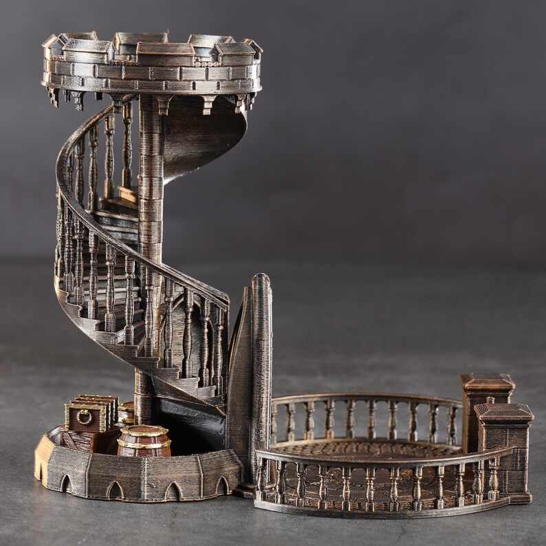 May include: A decorative metal tower with a spiral staircase and a balcony. The tower is made of a dark metal with a bronze finish. The tower is a miniature model and would be a great addition to a fantasy or medieval themed collection.