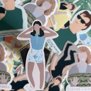May include: A collection of stickers featuring illustrations of people and text. The stickers are on a green and brown patterned surface. The main sticker is of a woman with long dark hair wearing a blue and white patterned shirt and white shorts. The text on the stickers includes "Everybody's Plate College The Hard Stuff To Me" and "I Carry A Water Melon".