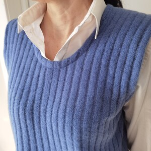 Puede incluir: Un chaleco de punto azul sin mangas con textura de canal&eacute;. El chaleco est&aacute; hecho de un material suave y peludo.