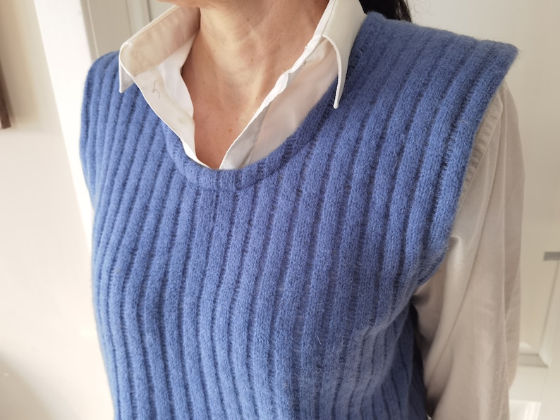 Puede incluir: Un chaleco de punto azul sin mangas con textura de canal&eacute;. El chaleco est&aacute; hecho de un material suave y peludo.