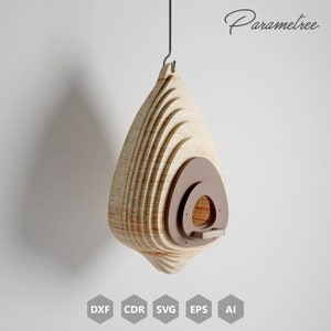 May include: A hanging wooden birdhouse with a teardrop shape. The birdhouse is made of layered light-colored wood with a brown circular entrance and a small perch. The word "Parametree" is written in cursive on the upper right.