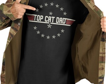 May include: A black t-shirt with a vintage-style graphic that says "Top Cat Dad" surrounded by stars. The graphic is in white and red.