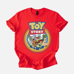 Puede incluir: Camiseta roja con un dise&ntilde;o gr&aacute;fico colorido de los personajes de la pel&iacute;cula "Toy Story". El dise&ntilde;o incluye el logotipo de la pel&iacute;cula y personajes como Woody, Buzz Lightyear y Rex. La camiseta es de material suave.