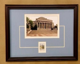 May include: A framed photograph of a building with columns and a blue sky. The photograph is surrounded by a white mat and a brown frame. A smaller photograph of the same building is in the lower right corner of the frame.