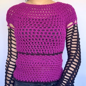 May include: A magenta crochet top with a boat neck and openwork design. The sleeves are black, with a net-like pattern. A dark brown horizontal stripe accents the waist area. The top is made of a soft, open weave material.