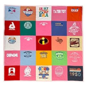 May include: A patchwork quilt made from various colorful t-shirts. Each square features a different design, including text like "Camp Sweeney," logos, and graphics. The quilt has a white border and is likely handmade, showcasing a variety of colors and patterns.